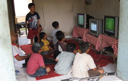 Balinesische Kinder an der Spielkonsole